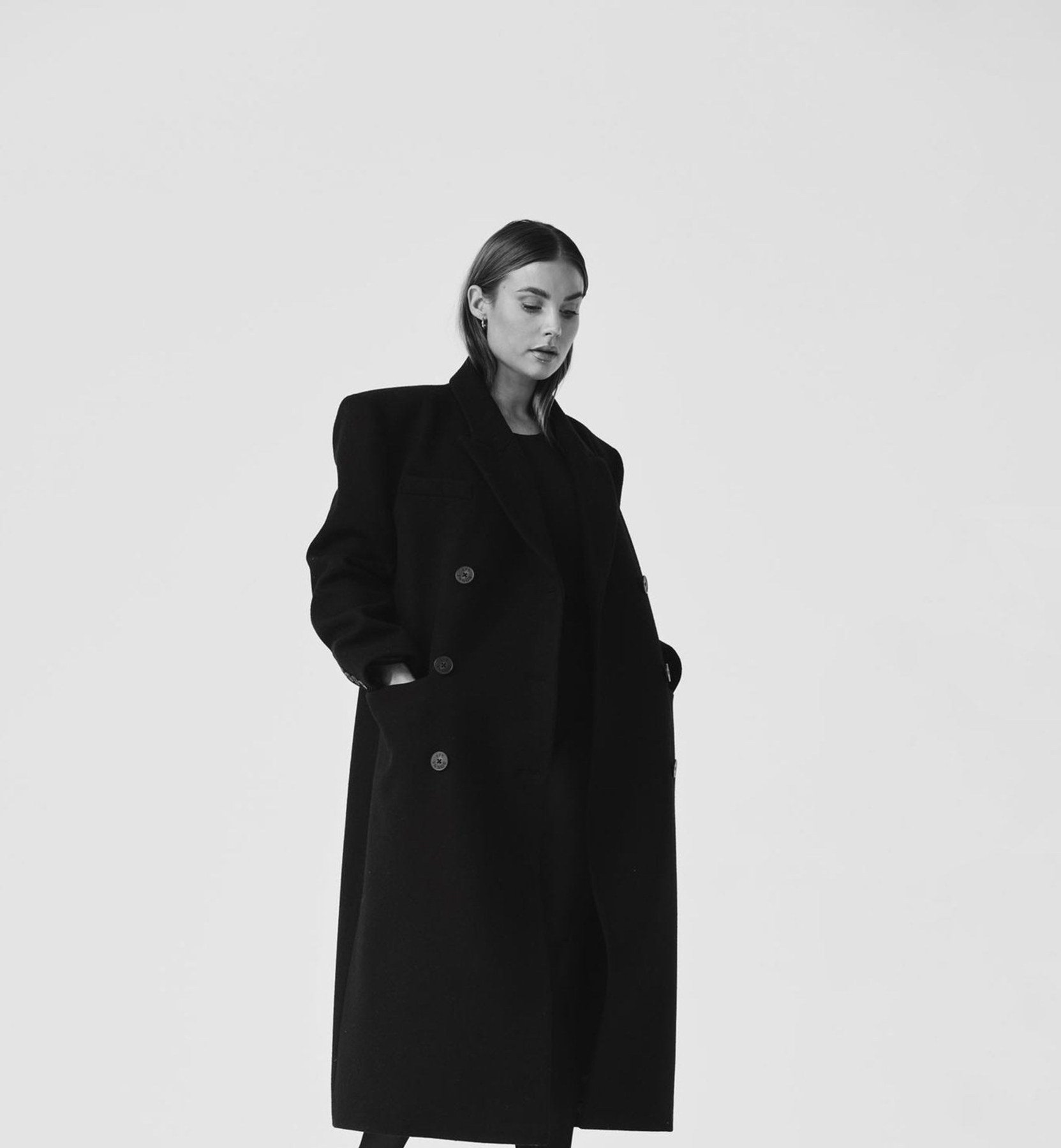 Editorial portrait in a sculptural black coat